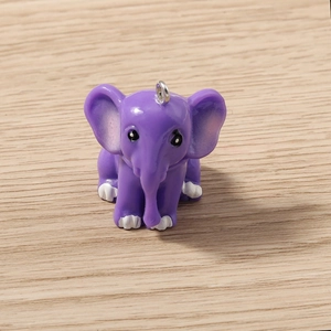 Macro detail of cute purple resin elephant pendant with silver loop for jewelry making