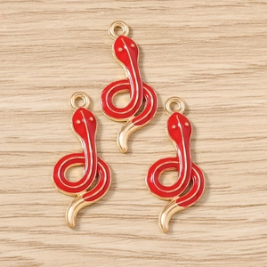 Detailed macro view of red enamel snake charms with gold plated alloy finish for DIY jewelry