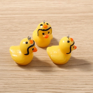 Vue détaillée de breloques canard 3D en résine jaune avec anneaux pour bijoux DIY