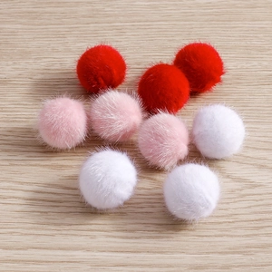 Close-up of soft faux mink fur balls in red, pink, and white for DIY jewelry making