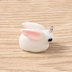 Detail of cute white rabbit resin pendant with pink ears and silver metal hanging loop