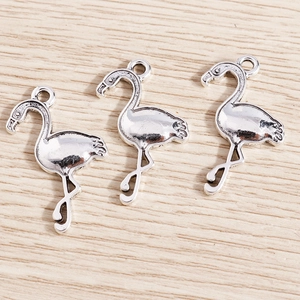 Detailed close-up of three antique silver flamingo pendants for jewelry making projects