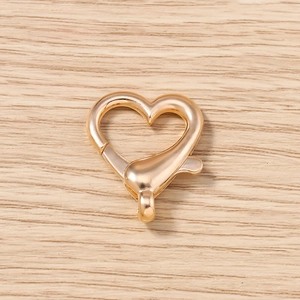 Vista macro di una chiusura a moschettone a forma di cuore in oro rosa per gioielli fai-da-te