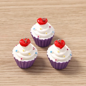 Λεπτομερής όψη τριών μενταγιόν cupcake από ρητίνη με κόκκινες καρδιές σε ξύλο
