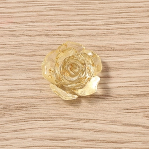 Dettaglio macro di ciondoli a forma di rosa in resina dorata con foglie d'oro interne