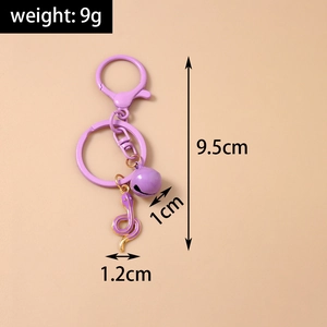 Detail view of purple snake keychain with golden edges and small bell, 9.5cm length