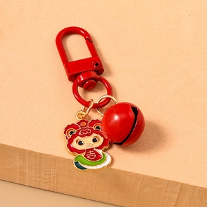 Detail of red cartoon lion keychain with large bell and traditional lucky charm