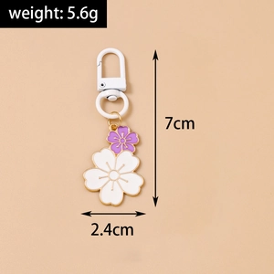 Detail showing dimensions of twin cherry blossom keychain with white and purple petals