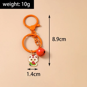 Detail of orange keychain with a red bell and a lucky lion dance charm, 8.9cm length