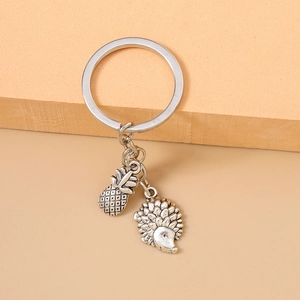 Vintage silver metal keychain with detailed pineapple and hedgehog charms for bags