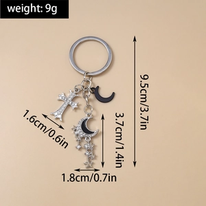 Détail du porte-clés avec pendentifs étoile, lune et croix avec indication du poids 9g