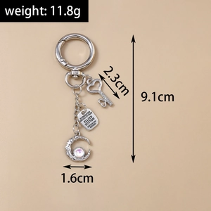 Detail of silver alloy keychain with purple moon and heart key pendants showing measurements