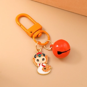 Close-up of orange dragon zodiac keychain with red bell and horseshoe buckle