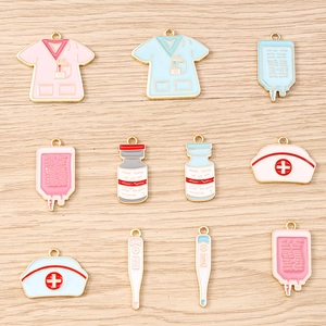 Vue à plat de breloques médicales en émail avec uniformes d'infirmière sur bois