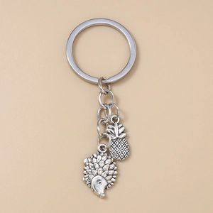 Silver metal keychain featuring detailed hedgehog and pineapple fruit charms on ring