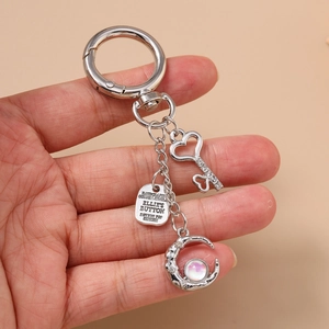 Silver metal keychain with heart crown and moon crescent pendant featuring an opal stone