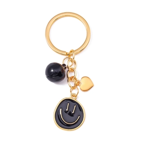 Porte-clés tendance en métal doré avec smiley en émail noir et pendentif coeur élégant