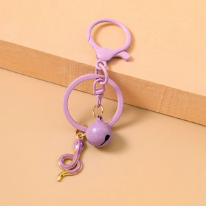 Detailed view of a purple snake keychain with golden edges and a small metal bell