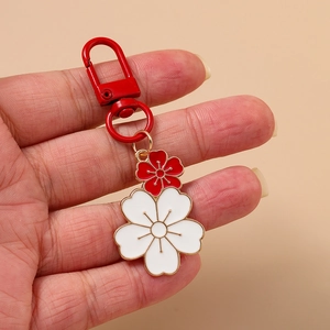 Fashionable cherry blossom keychain featuring red and white enamel flowers on a metal ring