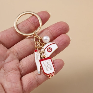 Detail of a medical-themed keychain featuring a nurse hat, thermometer, and IV bag charms