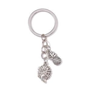 Silver metal keychain featuring detailed pineapple and hedgehog charms on a white background