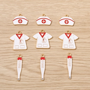 Lot de breloques en émail blanc : chapeau d'infirmière, uniforme et thermomètre