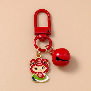 Detail of red cartoon zodiac sheep keychain with bell and lobster clasp on beige background