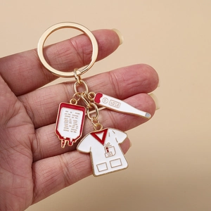 Golden medical nurse keychain with blood bag, thermometer and lab coat charms