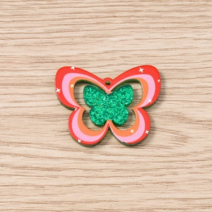 Detailed close-up of double-layered butterfly pendant with colorful patterns for DIY crafts
