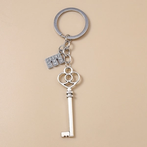 Detailed macro view of silver alloy heart-shaped key and rhinestone initial E charm keychain