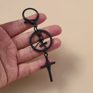 Detail eines schwarzen Gothic-Kreuz-Schlüsselanhängers mit Pentagramm und Karabiner