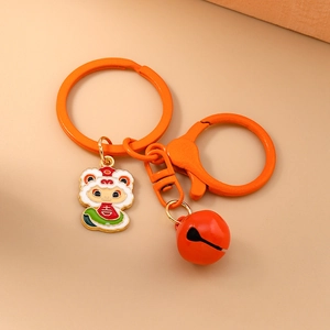 Close-up of vibrant orange lion dance keychain with red bell and lucky character charm