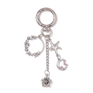 Porte-clés argenté avec breloques lune, étoile et fleur ornées de strass roses