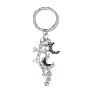 Détail de pendentifs croix gothique et lune argentée avec strass blancs et étoiles
