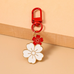 Detail of red and white enamel cherry blossom pendants with golden metal outline