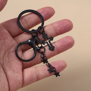Detail eines mattschwarzen Gothic-Schlüsselanhängers mit Kreuz und Sternen an einer Kette