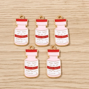 Vue macro de cinq pendentifs flacons médicaux émaillés rose et blanc avec anneaux dorés
