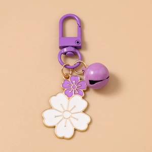 Detail of purple and white double cherry blossom keychain with gold trim and small bell