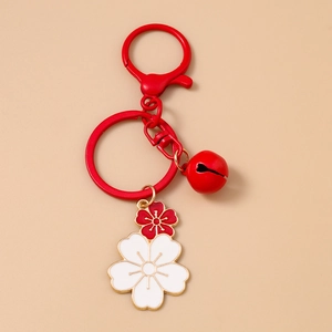 Macro detail of red and white cherry blossom enamel pendants with gold plating and ring