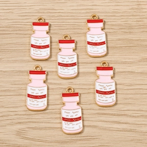 Lot de six breloques flacons médicaux avec émail rose et blanc et cadre doré