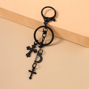 Detail eines gotischen schwarzen Metall-Schlüsselanhängers mit Kreuz und Halbmond