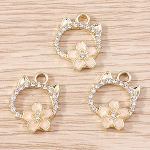 Detailed macro of golden cat-shaped cherry blossom pendants with white rhinestones