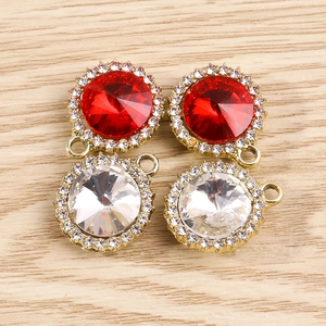 Détail macro de pendentifs ronds en pierres précieuses avec cristaux rouges et strass