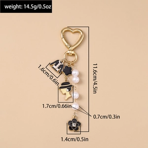 Detailed view of fashion keychain with camellia flower, pearl beads and female portrait charm