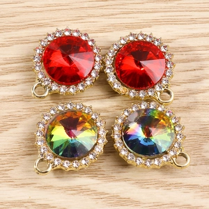 Vue de détails de pendentifs en pierres rouges et arc-en-ciel sertis de strass blancs dorés