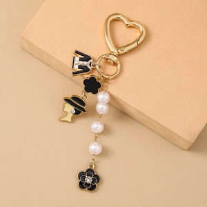 Fashionable heart-shaped pearl keychain with flower charm and elegant female portrait