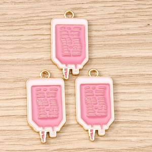 Détail de breloques de sac de perfusion rose avec bords dorés pour bijoux DIY