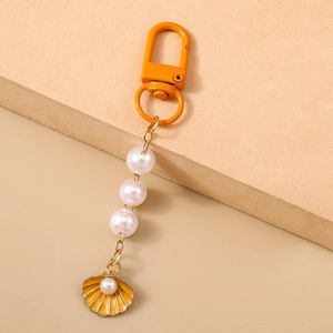 Detail of orange lobster clasp with white pearls and orange enamel shell charm