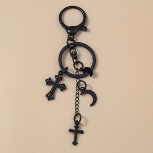Gotischer schwarzer Metall-Schlüsselanhänger mit Kreuz und Mond auf beigem Grund