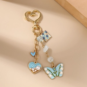 Detail of heart hook keychain featuring blue heart, floral butterfly and pearls